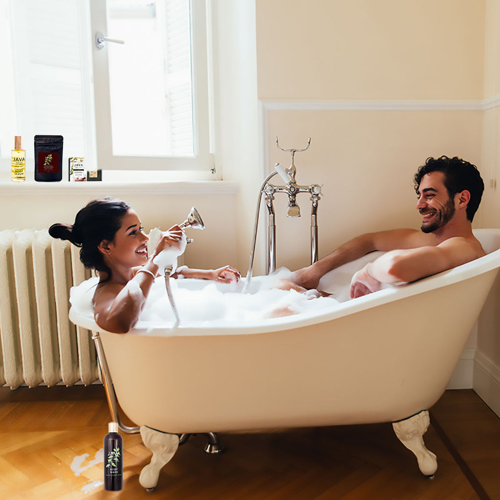 Couple sharing a bath in a claw foot tub and java products in the background