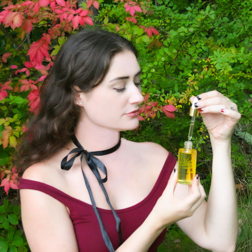 Model with JAVA Face Serum in outdoor fall setting
